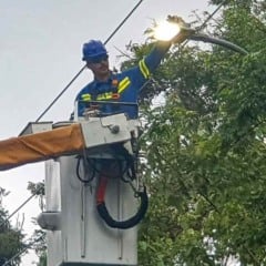 Trabalhador faz substitui&ccedil;&atilde;o de lumin&aacute;ria por LED em poste de ilumina&ccedil;&atilde;o p&uacute;blica usando caminh&atilde;o com cesto a&eacute;reo.