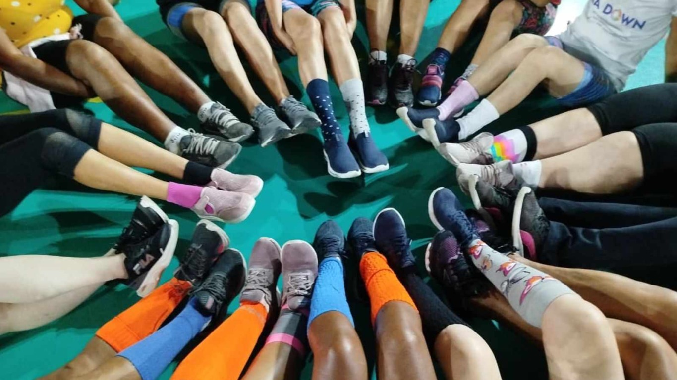 Participantes da Caminhada Inclusiva Teia Down utilizam meias coloridas, simbolizando a diversidade.