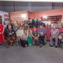 Idosos da Cidade Vicentina e equipe posam juntos no estande do Caf&eacute; Vicentino durante a Festa da Uva de Jundia&iacute;.