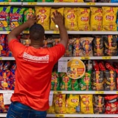 Funcion&aacute;rio da Americanas organiza g&ocirc;ndola com produtos em loja f&iacute;sica durante rotina de trabalho no varejo