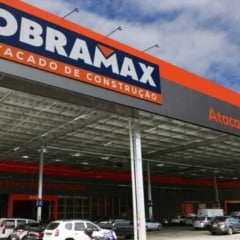 Fachada da Obramax em S&atilde;o Paulo, atacarejo de materiais de constru&ccedil;&atilde;o, com letreiro da marca e estacionamento com ve&iacute;culos.