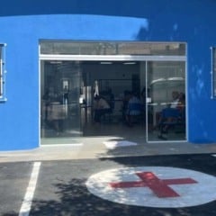 Fachada da USF Rio das Pedras, em Itupeva, reformada, com entrada de vidro, pintura azul e pacientes na sala de espera.