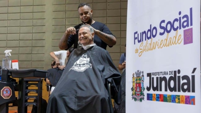Morador recebe corte de cabelo gratuito em ação do Fundo Social de Solidariedade da Prefeitura de Jundiaí durante evento comunitário.