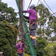 Trabalhadores realizam reordenamento de cabos em poste na Rua Centen&aacute;rio, em Jundia&iacute;, com uso de equipamentos de seguran&ccedil;a.