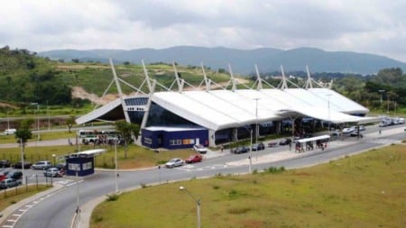 Terminal Rodoviário de Jundiaí com ônibus, carros e passageiros, em meio a área verde e montanhas ao fundo. Terminal Rodoviário de Jundiaí com ônibus, carros e passageiros, em meio a área verde e montanhas ao fundo.