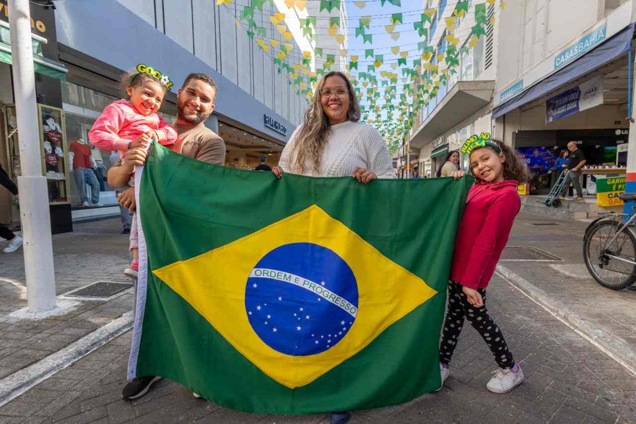 Centro de Jundiaí entra no clima da Copa e se prepara para virar ponto de encontro da torcida 1 Pessoas seguram uma bandeira do Brasil na Rua Barão de Jundiaí, decorada com bandeirinhas verdes e amarelas para a Copa no Centro.