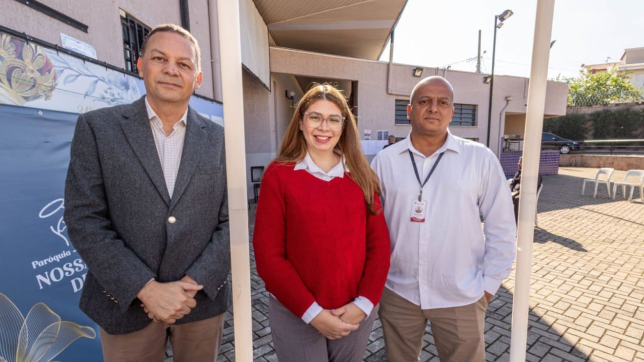 Pessoas em um mutirão de empregos, com estandes de empresas montados em área externa